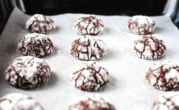 istock Chocolate cookies with powdered sugar on baking tray. Close-up. 2158857213