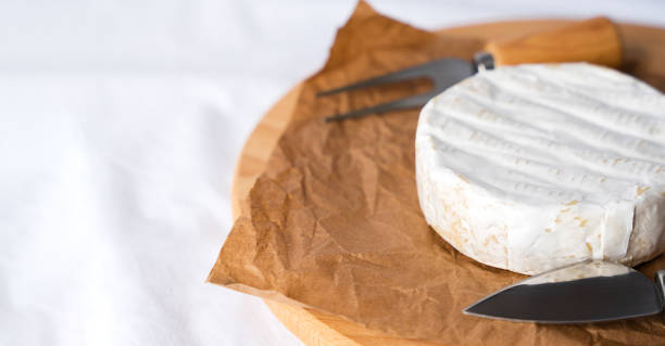 istock French soft cheese with white mold Camembert, knife and fork on the table. Breakfast concept. Close-up. Copy space. Selective focus. 2158857323