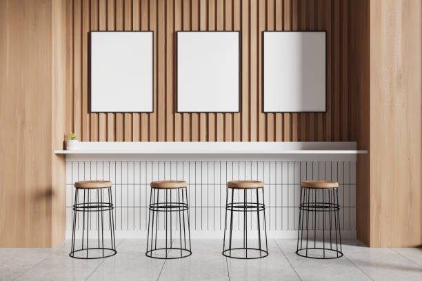 Modern minimalist bar interior with wooden stools and blank picture frames, wooden panel wall, light ambiance. 3D Rendering
