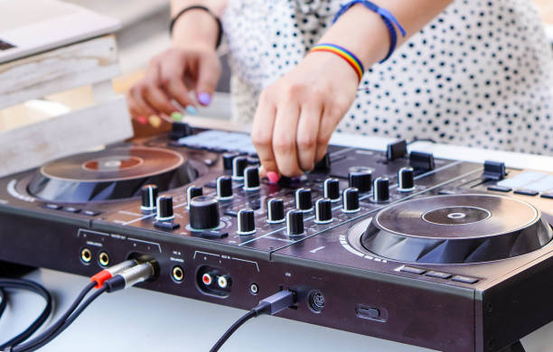 Dj on mixing desk. playing music at pride summer party.