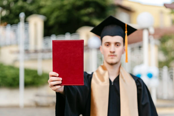 Proud High School Student Showing Diploma On Graduation Day