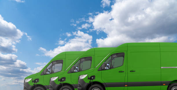 istock Green electric delivery vans with connected charging cables 2158864024