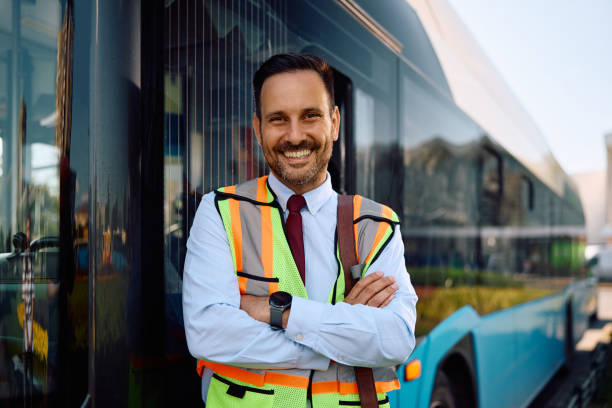istock Happy bus driver standing with arms crossed at looking at camera. 2158867367