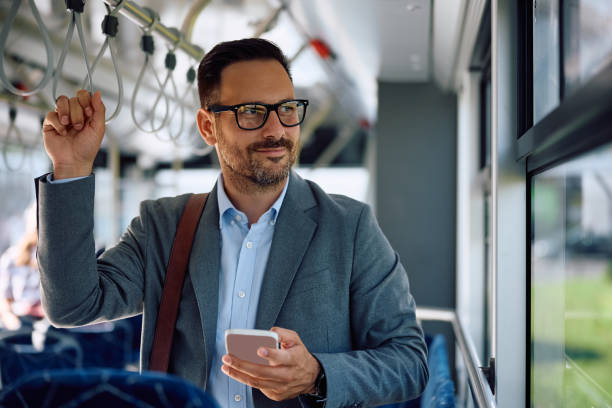 istock Smiling businessman going to work by city bus. 2158867396