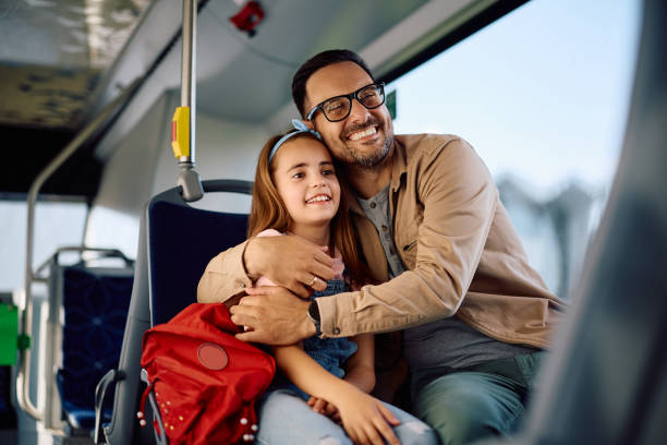 istock Happy father embracing his daughter while riding in a bus. 2158867550