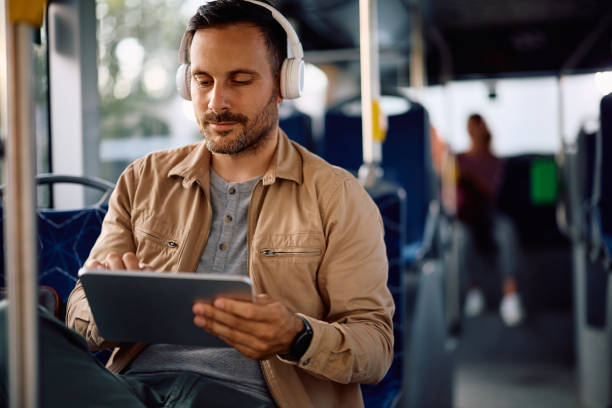 istock Male commuter surfing the net on touchpad while riding in a bus. 2158867679