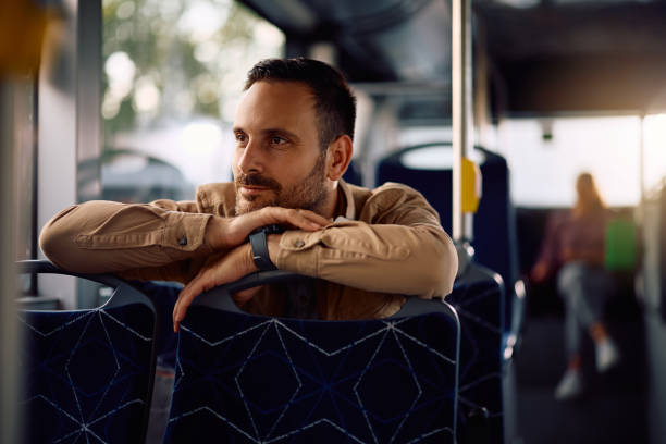 istock Smiling man day dreaming while riding in a bus. 2158867685