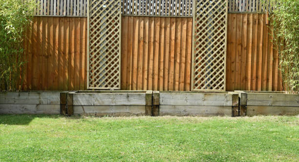 istock Empty railways sleeper raised garden beds. Lawn, fence and decorative trellis 2158867762