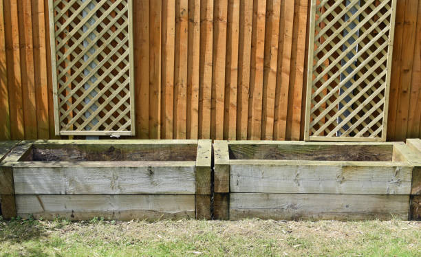 istock Empty railways sleeper raised garden beds. Lawn, fence and decorative trellis 2158867772