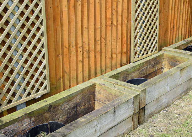 istock Empty railways sleeper raised garden beds. Lawn, fence and decorative trellis 2158867774