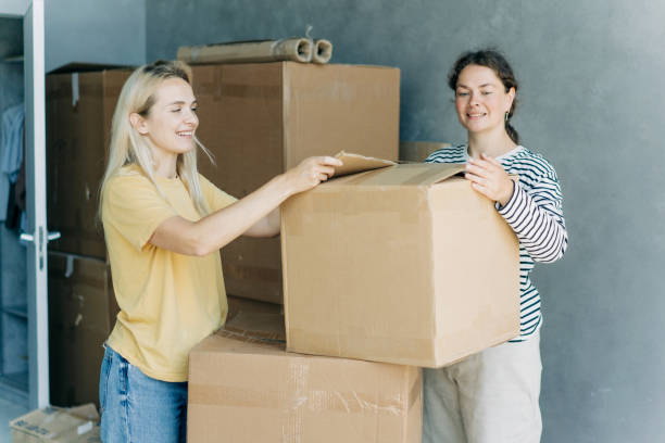 istock Happy women having fun while unpacking boxes and stuff while moving in a new home. 2158872754