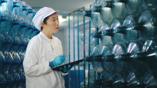 istock Professional Asian Female Quality Control Inspector with Digital Tablet in Water Bottling Plant. HACCP System in Bottled Water Production 2158874005
