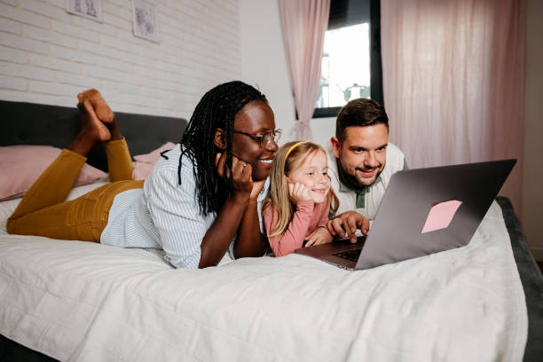 istock Happy family in bed using laptop 2158875320