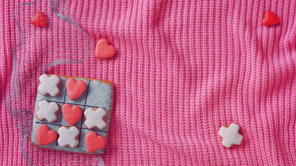 istock Noughts and crosses. Horizontal Banner for Website. Love Conception. Gingerbread on a Pink Sweater Background. Valentines Day Wallpaper 2158875529