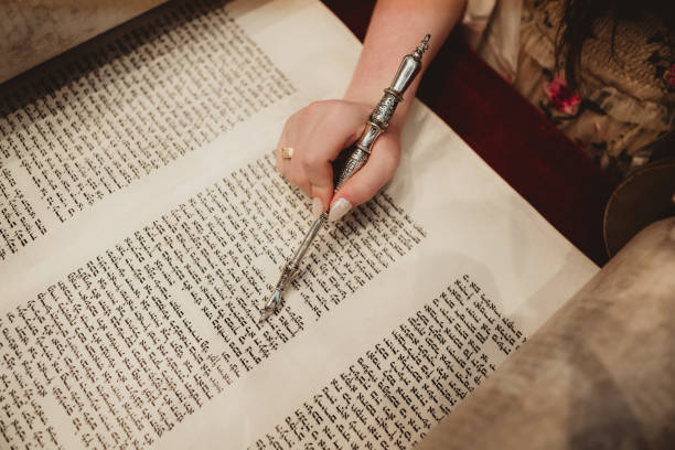 istock Young woman reading from torah scroll with Yad at bat mitzvah 2158881590
