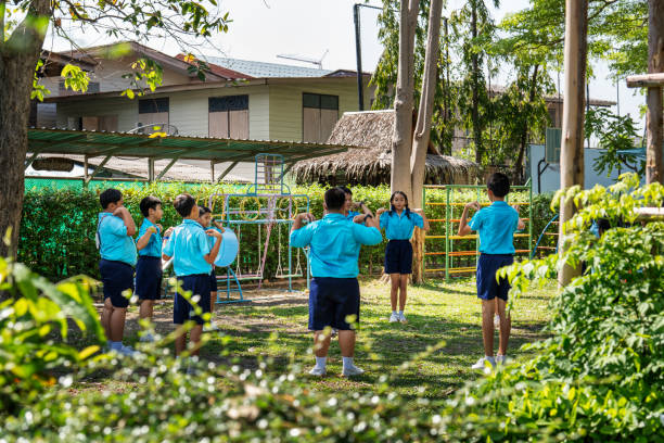 istock Children in school uniforms doing warm-up exercises during training class 2158881602