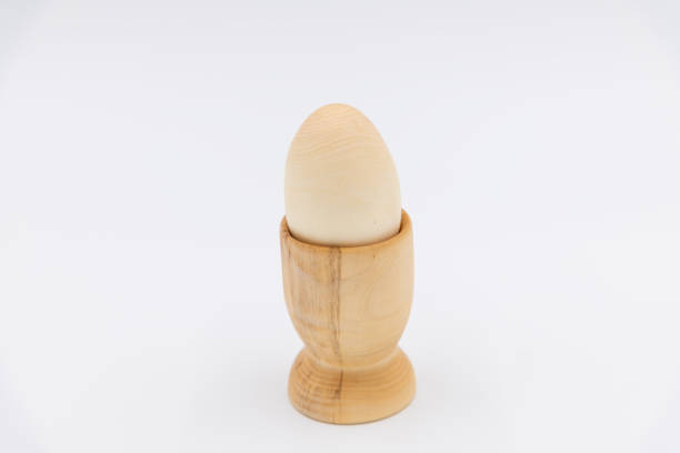 istock carved wooden egg in eggcup on white background 2158882049