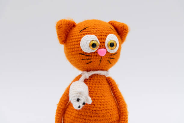 Orange knitted cat toy on white background
