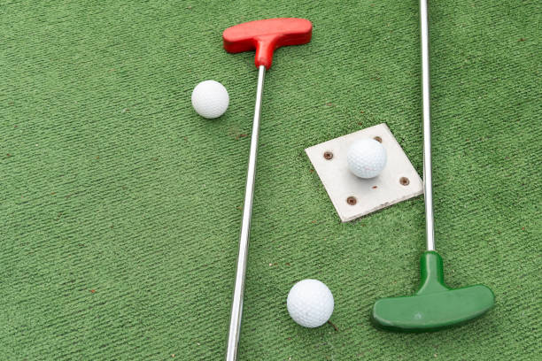 istock Mini golf. A club and a white ball on a golf course. 2158883767