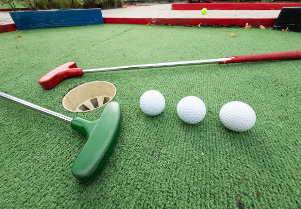 istock Fun vacation entertainment for summertime. Playing mini golf on green grass outdoors. Setting goals and winning lifestyle concept. Competition at golf course: two crossed sticks. Blank space for copy. 2158884055