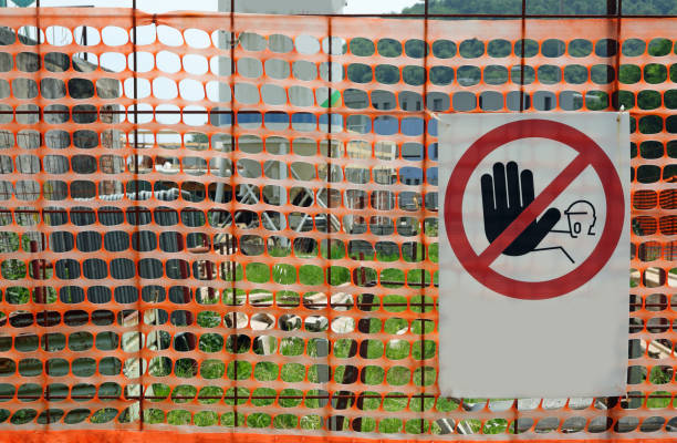 Construction site sign with NO ENTRY for unauthorized personnel written on it and an orange safety net without people