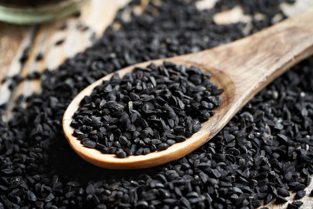 istock Black cumin or Nigella sativa seeds on a wooden spoon 2158887941