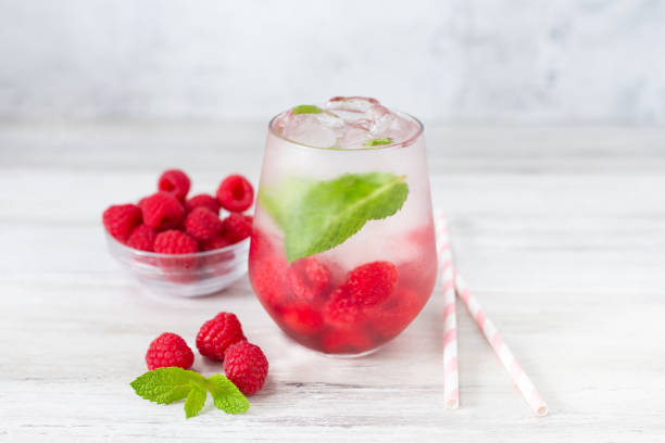 istock Cold refreshing lemonade drink or cocktail made of water, raspberry and mint. Served drinking glass with ice cubes. 2158895375