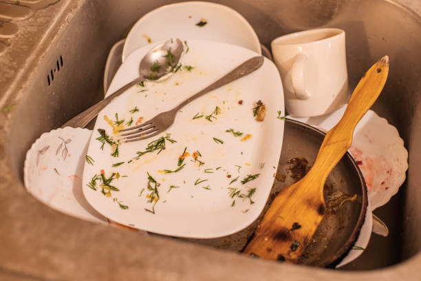 In a restauran kitchen, a few piles of dirty dishes waiting to be washed