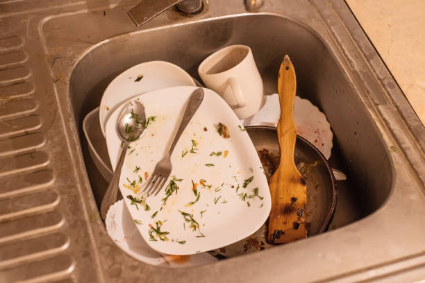 A stack of dirty dishes on black.