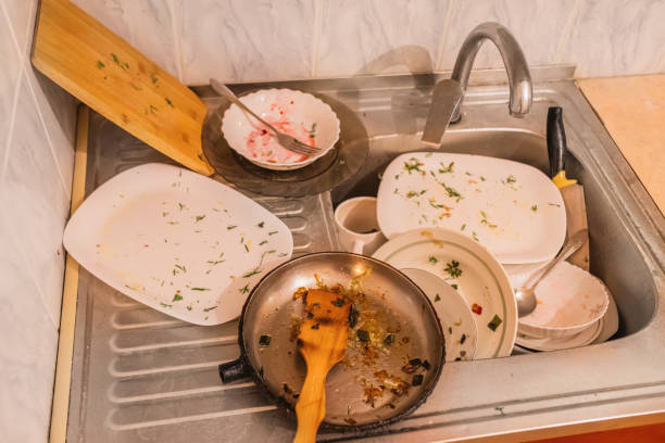 Dirty frying pan and dirty pots on a dirty stove. All things nned a washing.