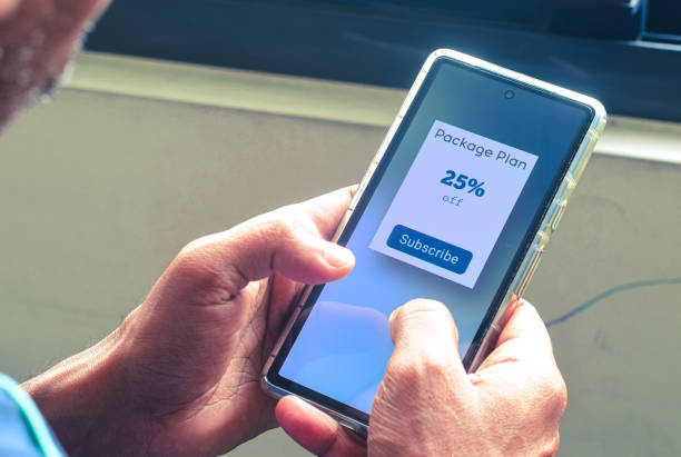 istock Man looking at his mobile phone displaying a package plan for subscription offer. Digital newspaper, delivery or streaming service subscription plan concept. 2158911781