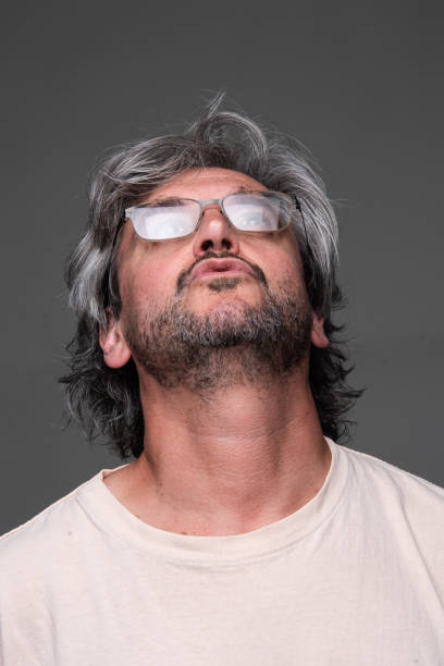 istock Mature man looking up on  gray background 2158912815