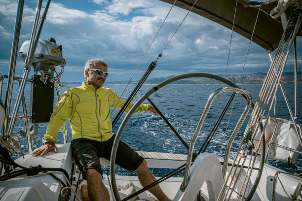 istock A man wearing a straw hat is driving a sailboat and enjoying it. 2158913397