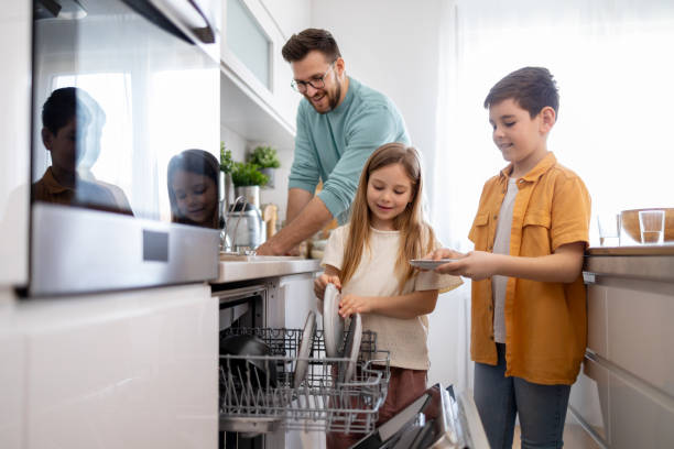 istock Family working together to unload dishwasher 2158914792