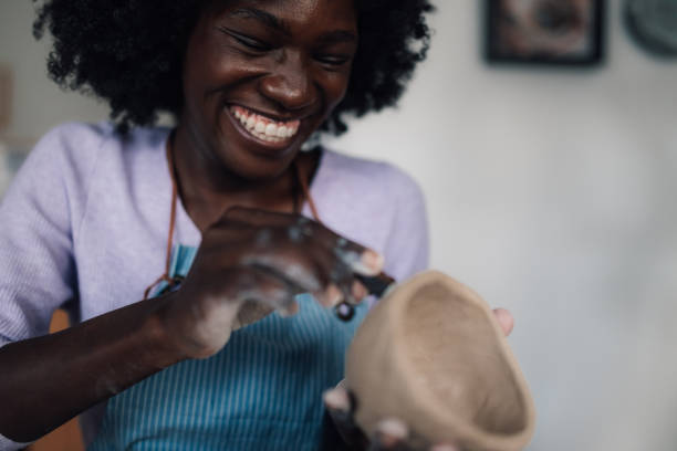 istock Happy diverse pottery course attendee imprinting on clay mug at studio 2158915265