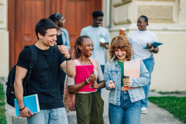 istock Three diverse happy students at campus near university building chatting 2158915308