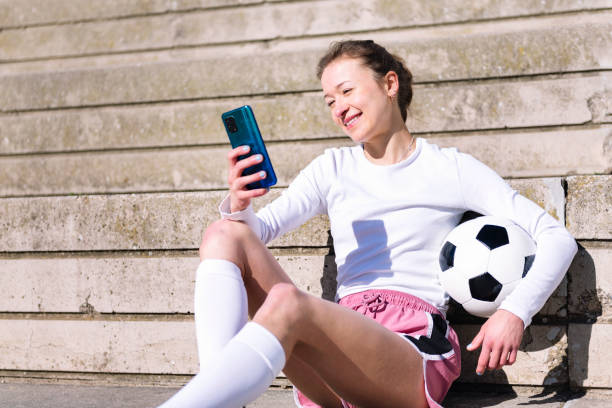 istock female soccer player resting using mobile phone 2158915358