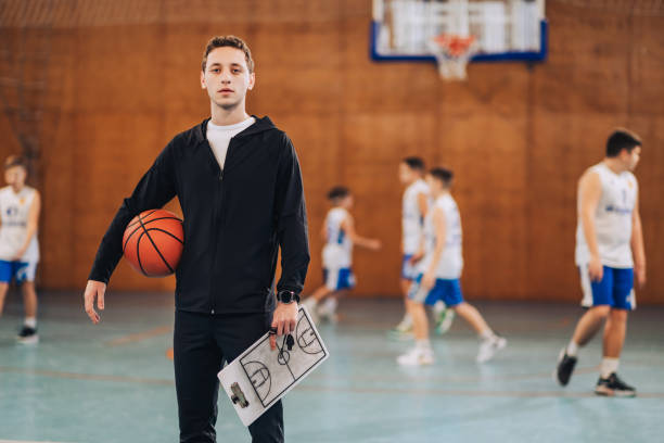 istock Basketball coach walking in gym with clipboard 2158915400