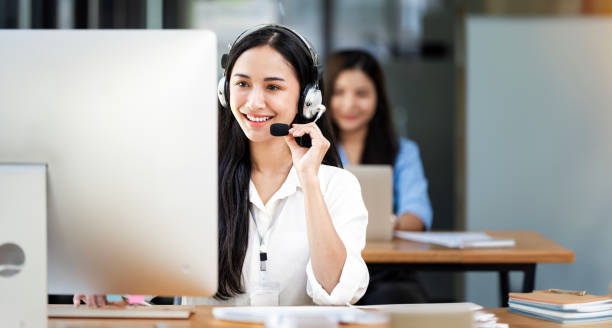 smiling customer support operator at work. - pessoal de assistência a clientes imagens e fotografias de stock