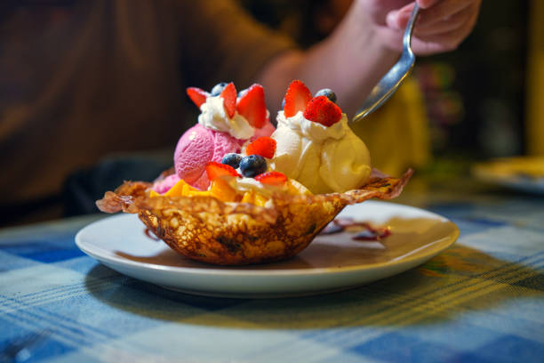 Close-up of waffles with fruit pieces, cherries, chocolate sauce and toffee sprinkles