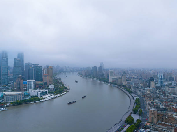 Shanghai, China - May 24th 2024: Traditional block square in Shanghai next to the River Huangpu, Behind you see the skyline of Pudong New Area in Shanghai. Pollution is a steady companion causing smog