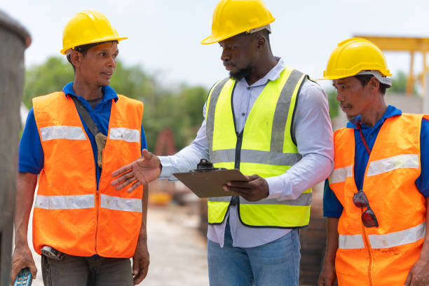 istock Foreman and workers team meeting for planning project at construction site, Site manager and builder control concrete truck mixer on construction site 2158932052