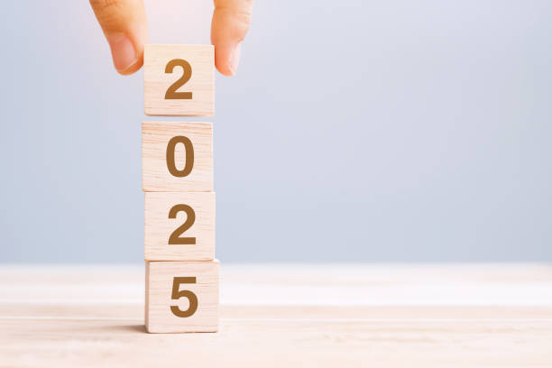 istock hand holding wooden cube block with 2025 text on table background. Resolution, plan, review, goal, start and New Year holiday concepts 2158932625