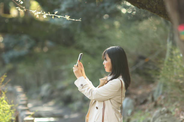 istock Beautiful woman taking photo at spring park 2158932701