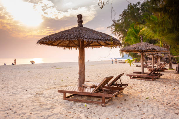 istock Wooden chairs and umbrellas on white beach 2158933378