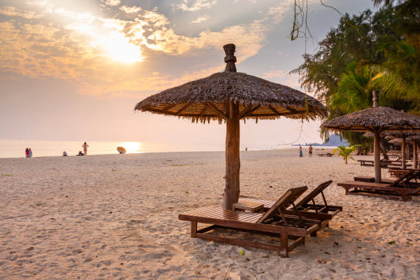 istock Wooden chairs and umbrellas on white beach 2158933380