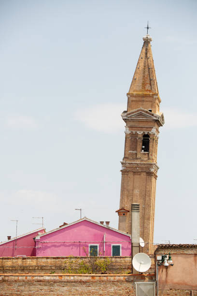 Burano, Venice, Italy, June, 26, 2023: Exterior of the famous leaning bell tower of Burano, an island in the Ventian Lagoon, northern Italy, known for its lace work.