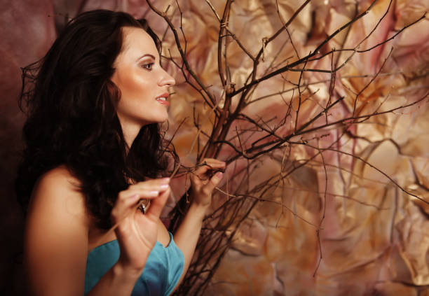 Young woman with bright make up with dry branches