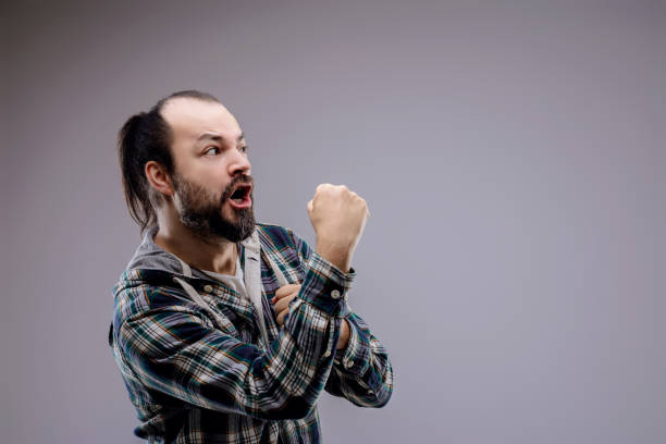 istock Angry man with beard is shouting with clenched fists 2158941634