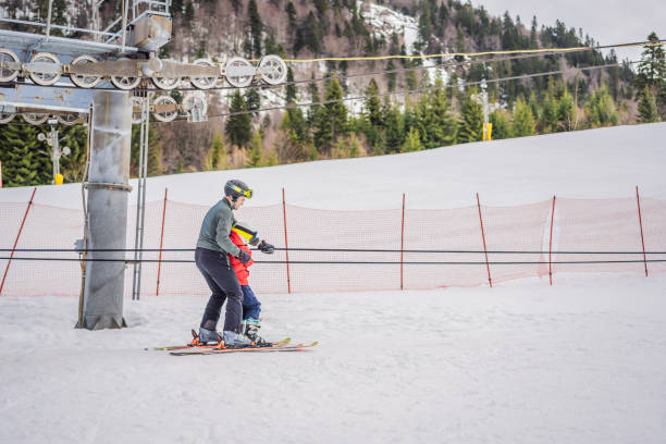 istock Instructor teaches boy skier to use on ski lift 2158941780